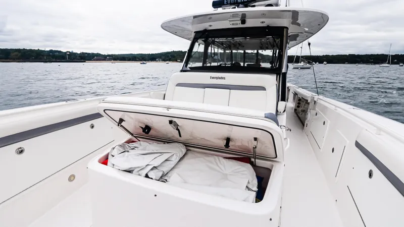  Yacht Photos Pics 2017 Everglades 435 CC boat with open storage compartment on deck, docked on calm water.