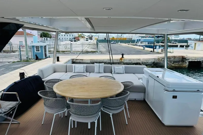 El Nino Yacht Photos Pics Luxurious 2024 Lagoon 65 yacht deck with seating, table, and waterfront view.