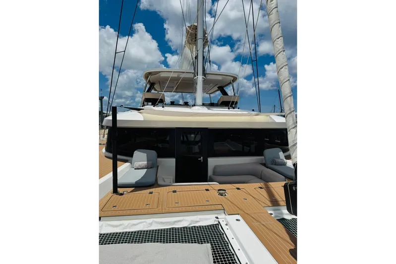 El Nino Yacht Photos Pics 2024 Lagoon 65 yacht with spacious deck and modern design under blue sky.