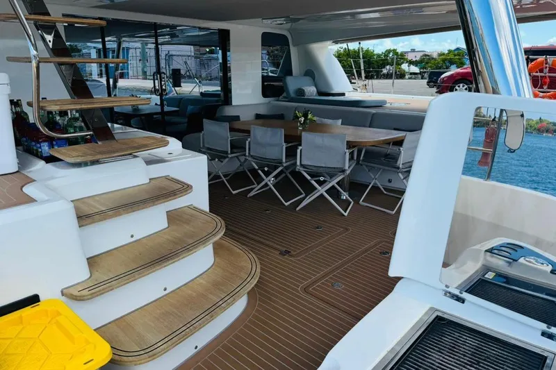 El Nino Yacht Photos Pics Luxurious 2024 Lagoon 65 yacht interior with elegant seating and wooden stairs.