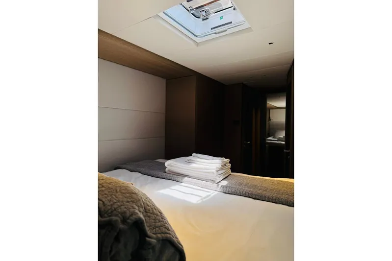 El Nino Yacht Photos Pics Luxurious interior cabin of 2024 Lagoon 65 yacht with skylight and cozy bedding.
