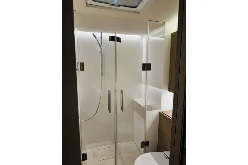 El Nino Yacht Photos Pics Modern shower area in 2024 Lagoon 65 yacht, featuring sleek glass doors and contemporary fixtures.