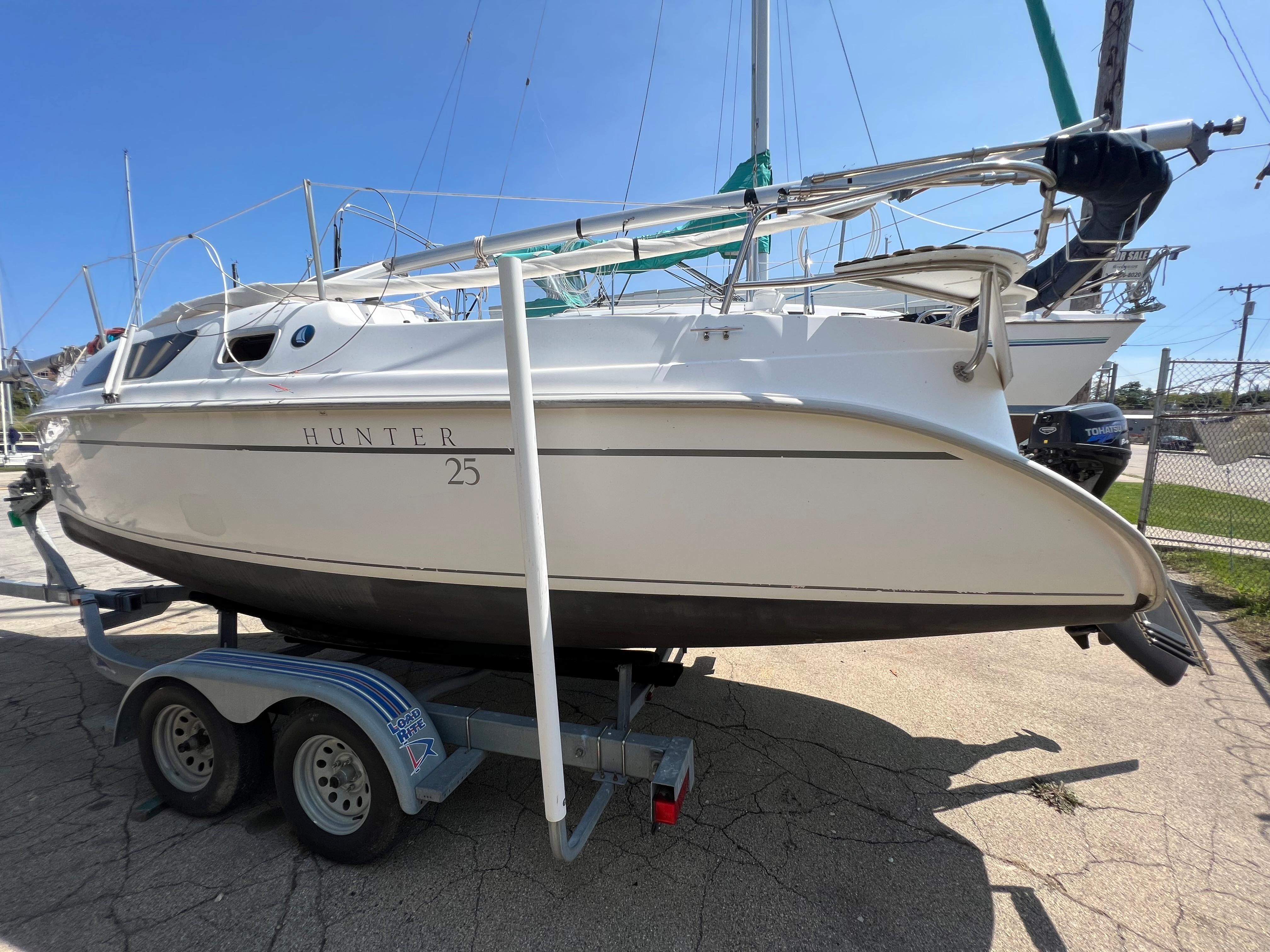 2007 Hunter 25 sailboat on trailer, side view, sunny day.