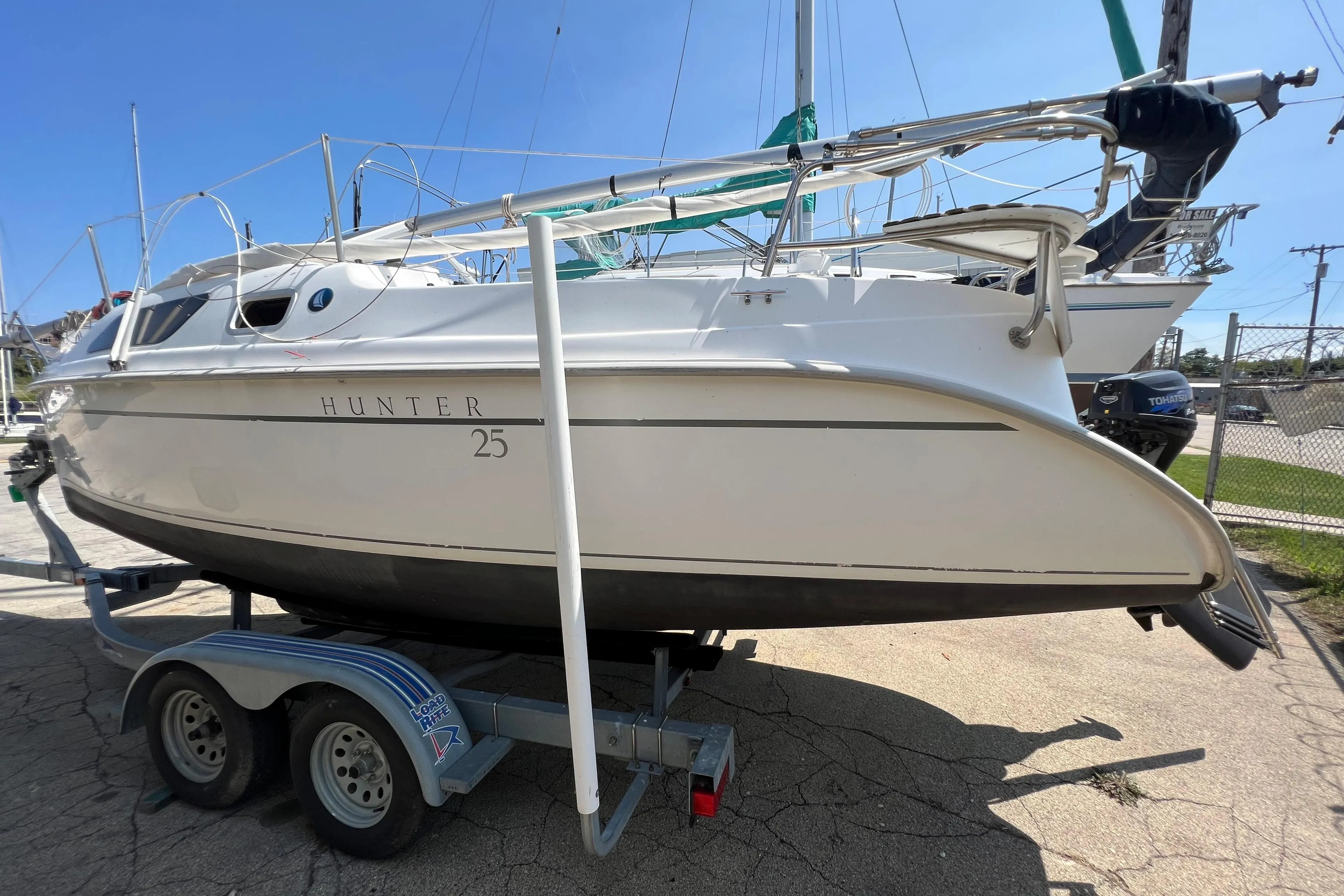 2007 Hunter 25 sailboat on trailer, side view, sunny day.
