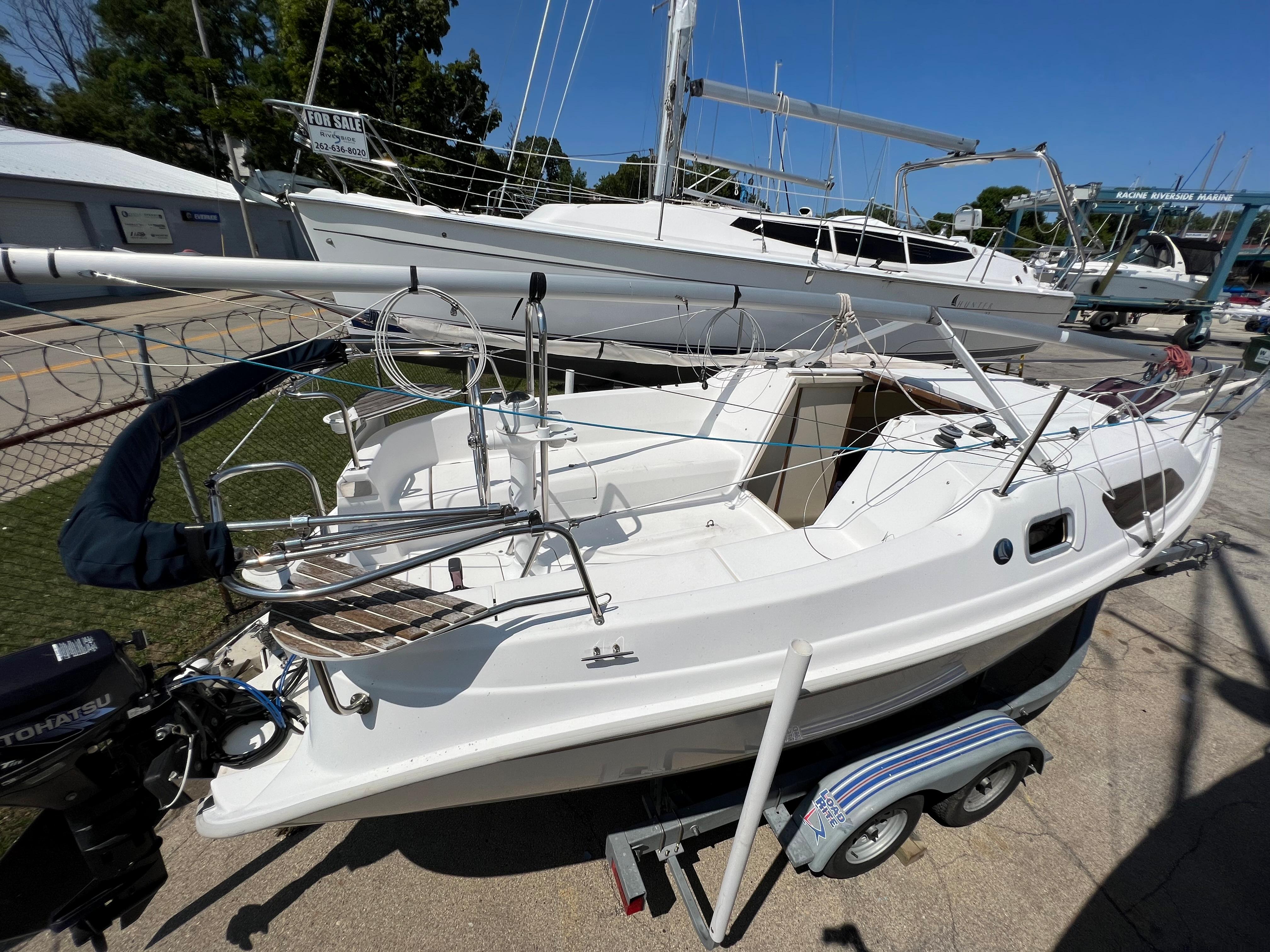 2007 Hunter 25 sailboat on trailer, docked in marina under clear blue sky.
