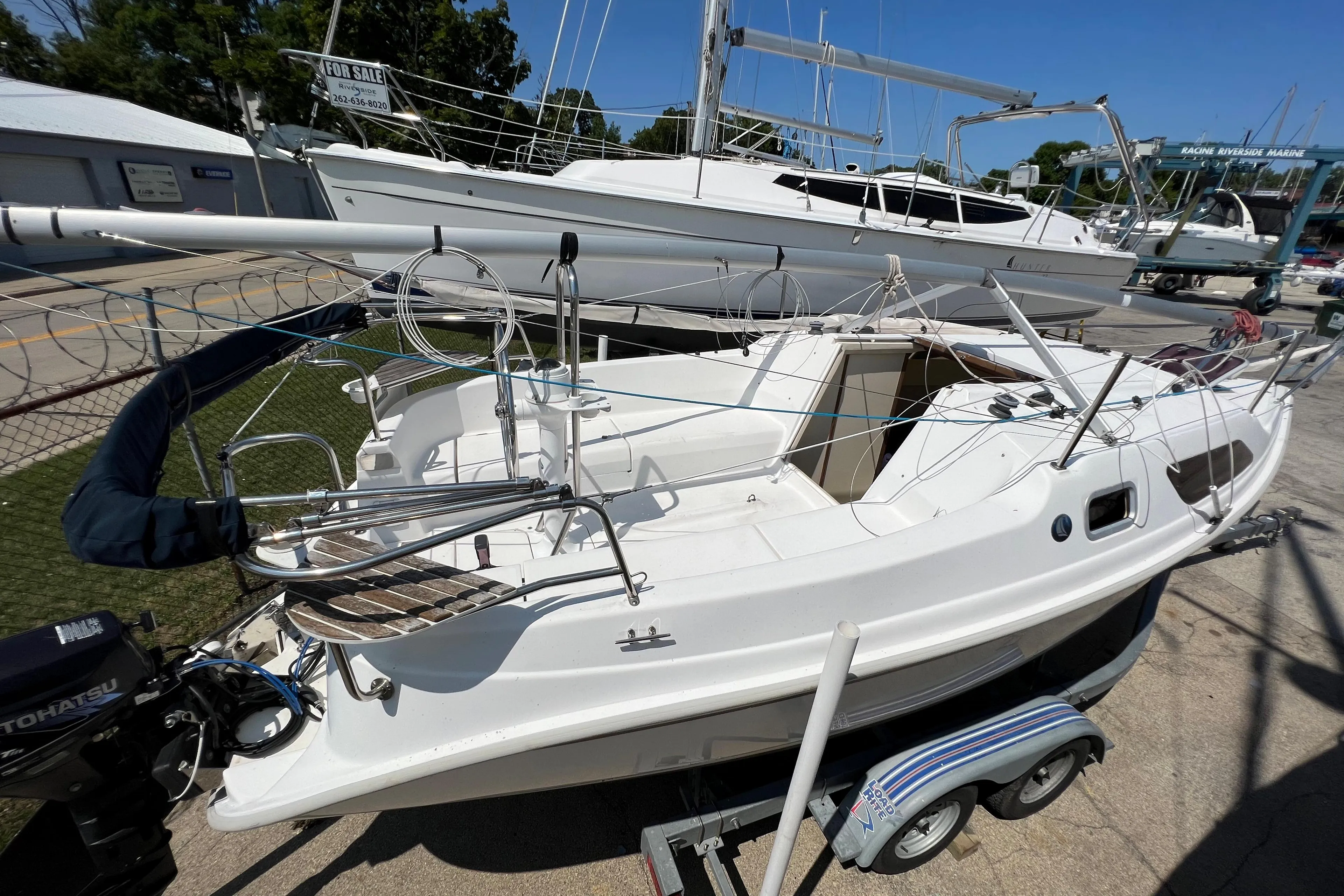2007 Hunter 25 sailboat on trailer, docked in marina under clear blue sky.