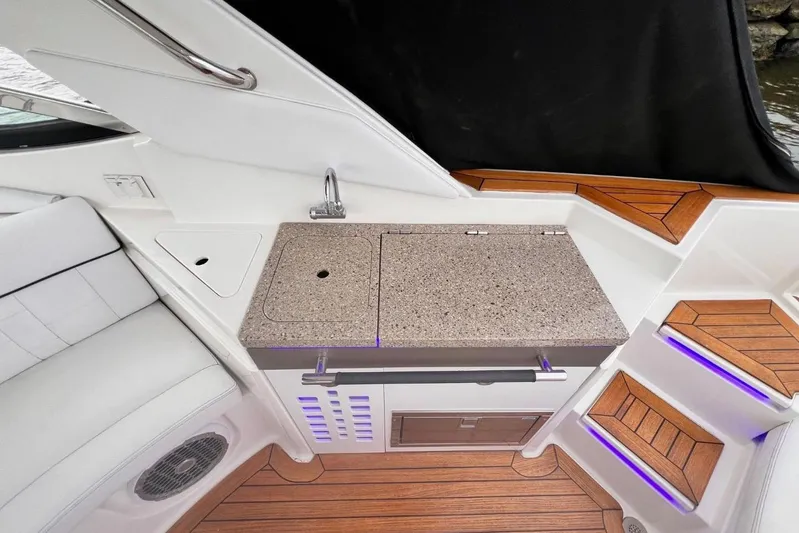  Yacht Photos Pics Luxurious 2014 Sea Ray SLX 350 boat interior with kitchenette and wooden flooring.