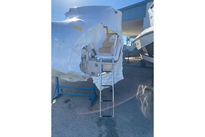  Yacht Photos Pics 2026 Grady-White Freedom 325 boat, partially covered, with a ladder in a marina.