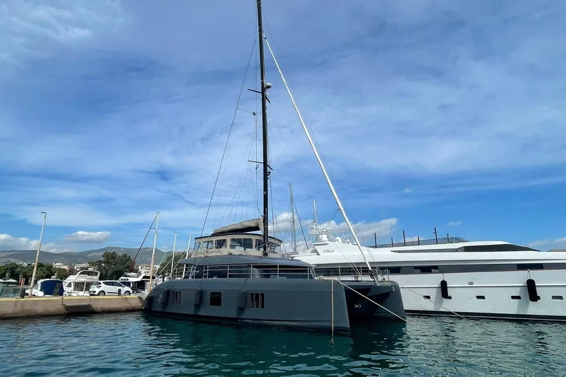 Ksenia Yacht Photos Pics 2024 Sunreef 60 yacht docked in a marina under a clear blue sky.