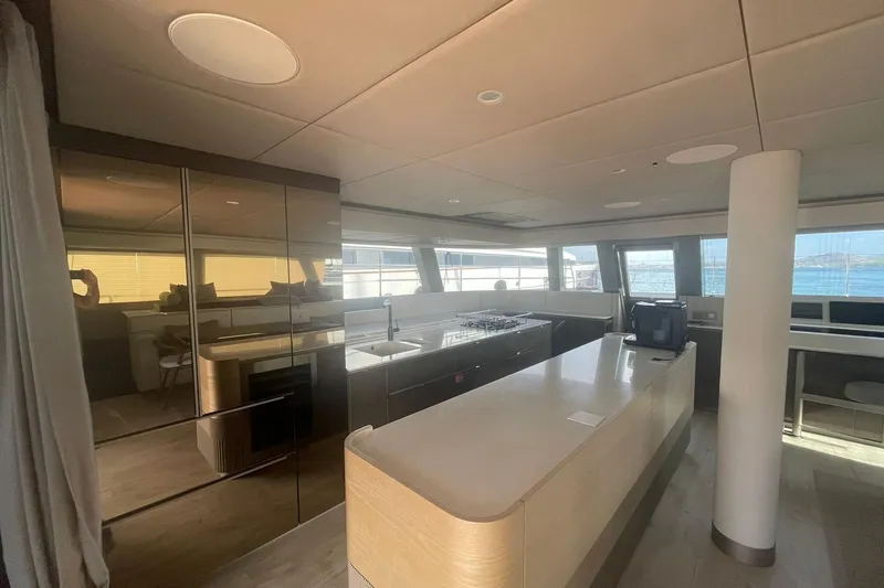 Ksenia Yacht Photos Pics Luxurious interior of 2024 Sunreef 60 yacht with modern kitchen and panoramic windows.