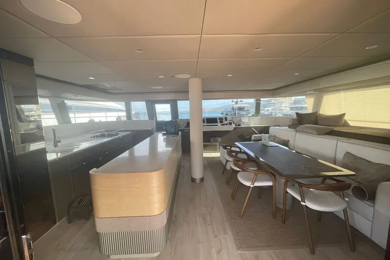 Ksenia Yacht Photos Pics Luxurious interior of 2024 Sunreef 60 yacht with modern kitchen and dining area.