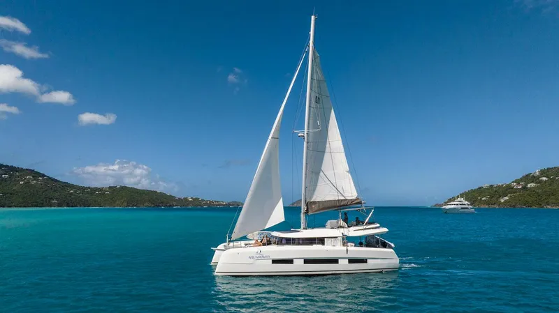  Yacht Photos Pics 2021 Dufour Catamarans 48 sailing in clear blue waters under a sunny sky.