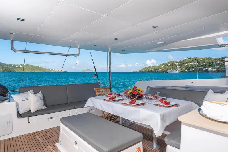  Yacht Photos Pics Luxurious 2021 Dufour Catamarans 48 with elegant dining setup overlooking serene blue waters.
