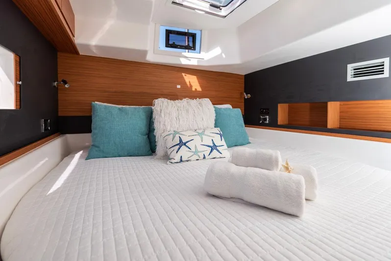  Yacht Photos Pics Luxurious bedroom interior of 2021 Dufour Catamarans 48 with cozy bedding and natural light.