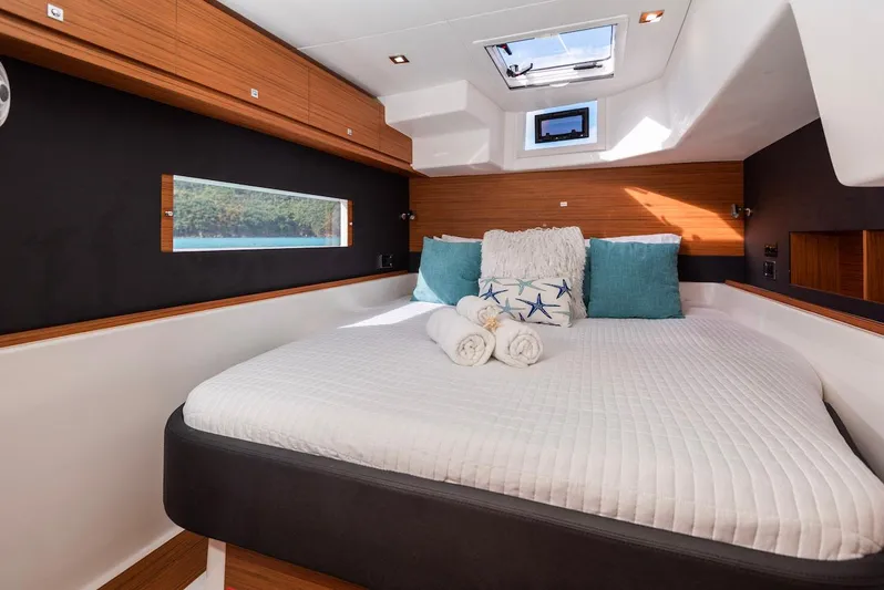  Yacht Photos Pics Luxurious bedroom interior of 2021 Dufour Catamarans 48 with plush bedding and natural light.
