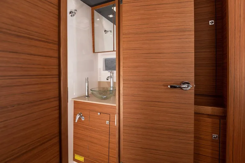  Yacht Photos Pics Modern bathroom interior on 2021 Dufour Catamarans 48, featuring wood finish and glass sink.
