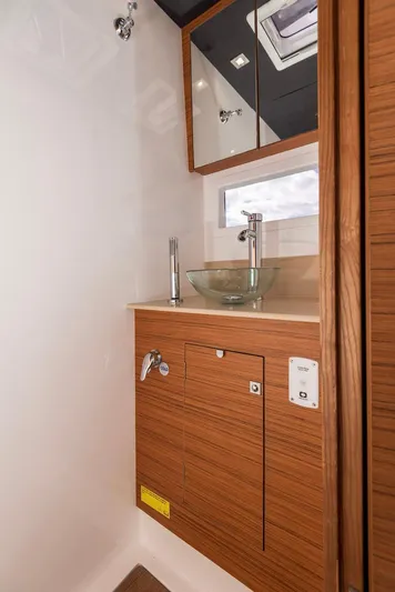  Yacht Photos Pics 2021 Dufour Catamarans 48 bathroom with modern sink and wooden cabinetry.