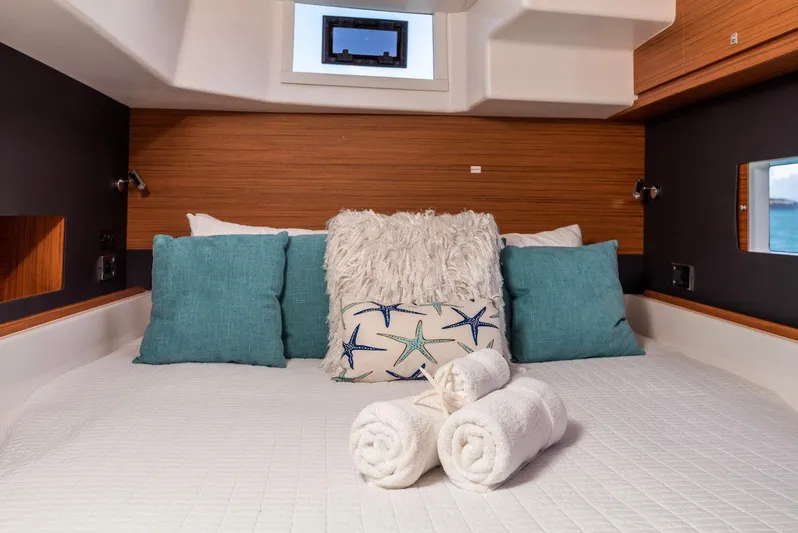  Yacht Photos Pics Luxurious bedroom interior of 2021 Dufour Catamarans 48 with plush pillows and rolled towels.