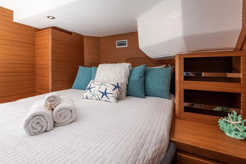  Yacht Photos Pics Luxurious cabin interior of 2021 Dufour Catamarans 48 with cozy bedding and wooden accents.