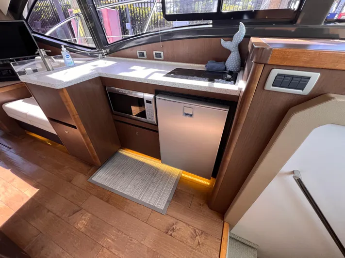  Yacht Photos Pics Interior of 2016 Sea Ray 400 Sundancer yacht kitchen with modern appliances and wood flooring.