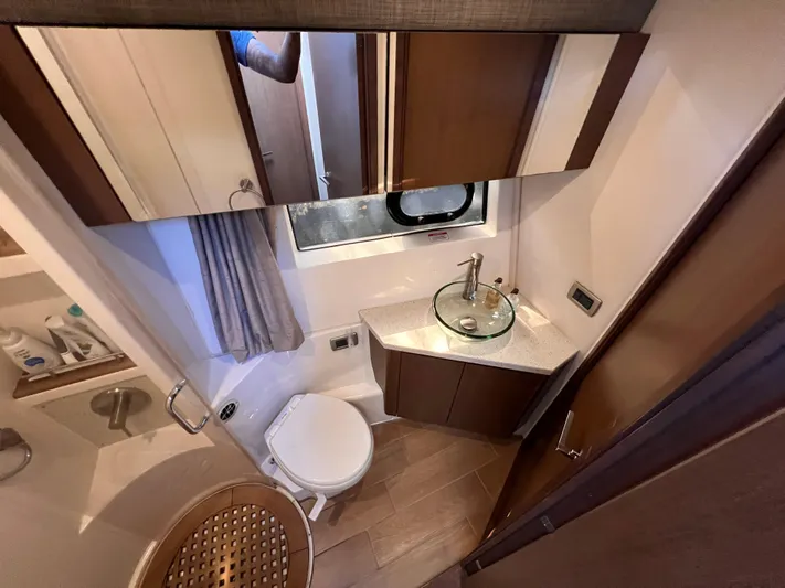  Yacht Photos Pics Luxurious bathroom in 2016 Sea Ray 400 Sundancer yacht with modern fixtures and wood accents.