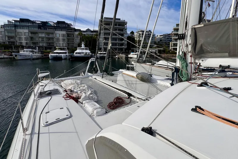 Alegria Yacht Photos Pics 2017 Outremer 51 catamaran docked in a marina with modern buildings in the background.