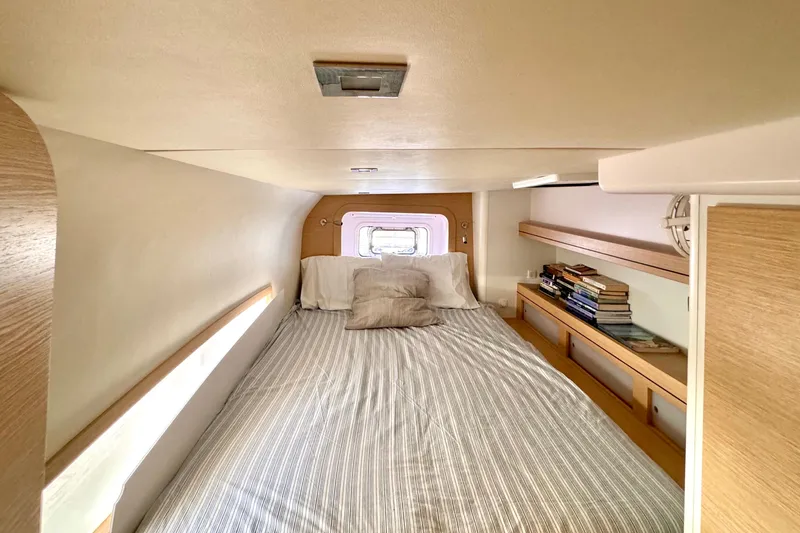 Alegria Yacht Photos Pics Cozy cabin interior of 2017 Outremer 51 yacht with bed and bookshelves.