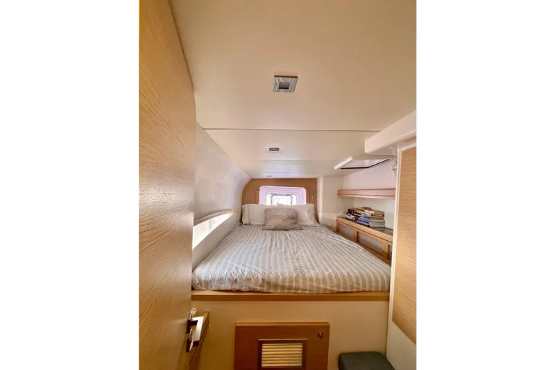 Alegria Yacht Photos Pics Cozy cabin interior of 2017 Outremer 51 yacht with bed and bookshelves.