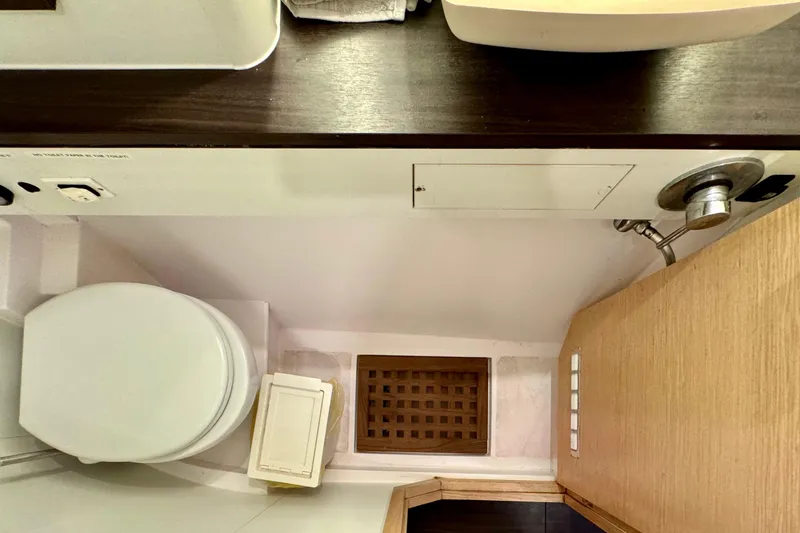 Alegria Yacht Photos Pics Bathroom interior of 2017 Outremer 51 yacht, featuring toilet and wooden cabinetry.