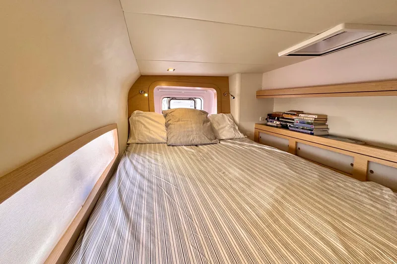 Alegria Yacht Photos Pics Cozy cabin interior of 2017 Outremer 51 yacht with bed and bookshelf.