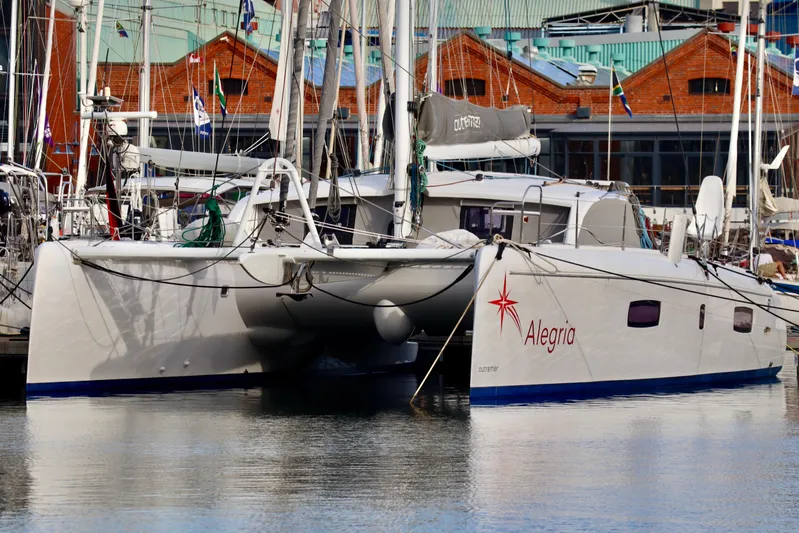 Alegria Yacht Photos Pics 2017 Outremer 51 catamaran "Alegria" docked at a marina with other sailboats.