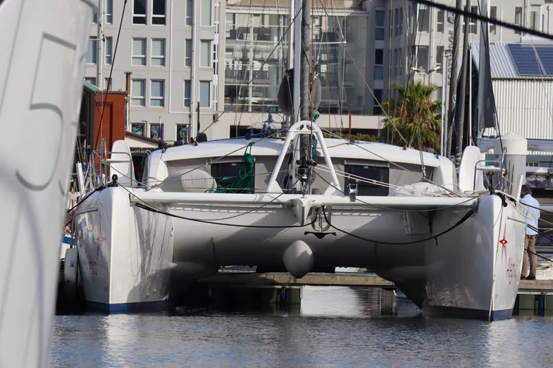 Alegria Yacht Photos Pics 2017 Outremer 51 catamaran docked in a marina, surrounded by modern buildings.