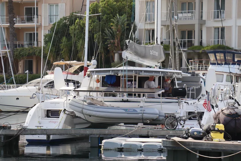 Alegria Yacht Photos Pics 2017 Outremer 51 catamaran docked at a marina with nearby buildings.