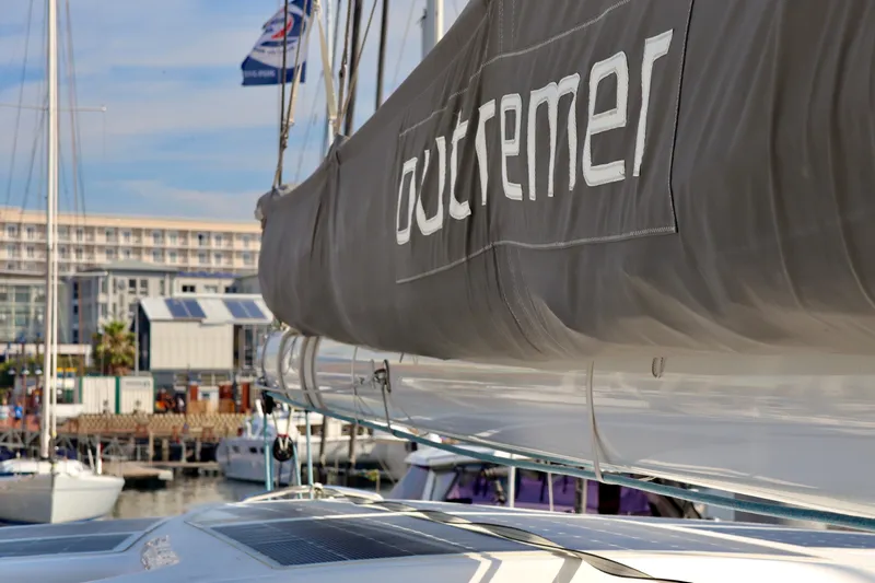 Alegria Yacht Photos Pics 2017 Outremer 51 catamaran docked at a marina, showcasing its sail and branding.
