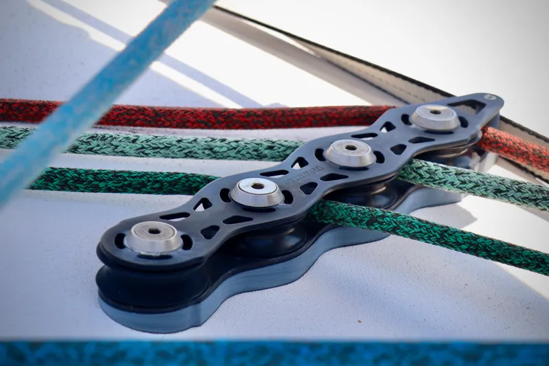 Alegria Yacht Photos Pics Close-up of Outremer 51 sailboat rigging system, featuring colorful ropes and pulleys.