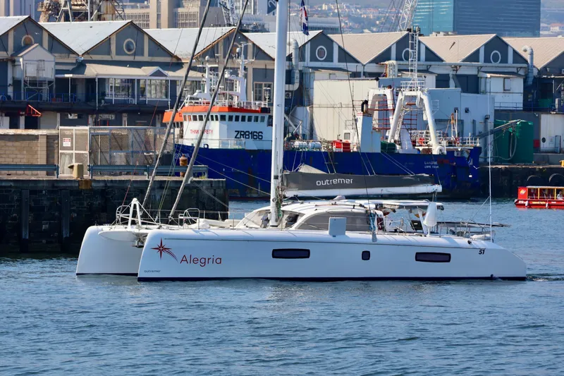 Alegria Yacht Photos Pics 2017 Outremer 51 catamaran "Alegria" docked in a bustling harbor.