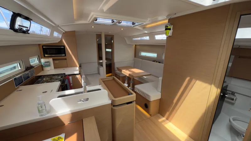  Yacht Photos Pics Interior of 2022 Jeanneau Sun Odyssey 410 yacht, featuring modern kitchen and dining area.