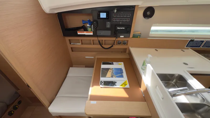  Yacht Photos Pics Interior of 2022 Jeanneau Sun Odyssey 410 yacht, featuring a compact dining area and control panel.