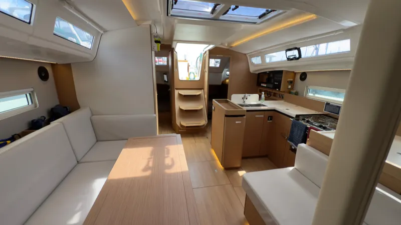  Yacht Photos Pics Interior of 2022 Jeanneau Sun Odyssey 410 yacht, featuring modern kitchen and seating area.