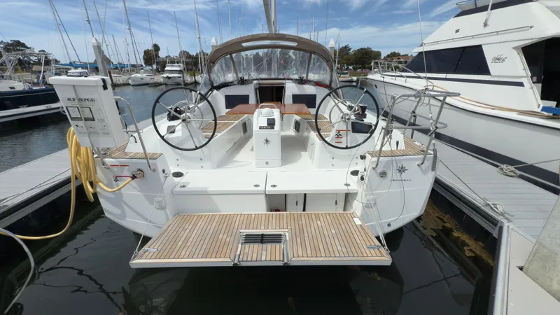  Yacht Photos Pics 2022 Jeanneau Sun Odyssey 410 yacht docked at marina, featuring dual steering wheels.