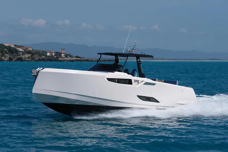 400 Wa Yacht Photos Pics 2025 Cayman Yachts 400 WA cruising on blue ocean near coastal landscape.