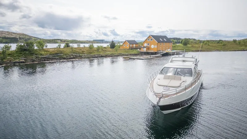  Yacht Photos Pics 2008 Azimut 62S yacht cruising near yellow houses on a serene waterfront.