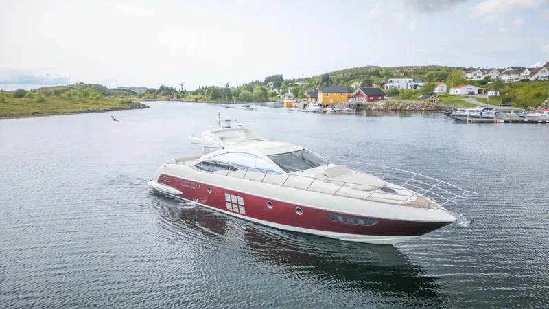  Yacht Photos Pics 2008 Azimut 62S yacht cruising in a scenic coastal area with houses in the background.