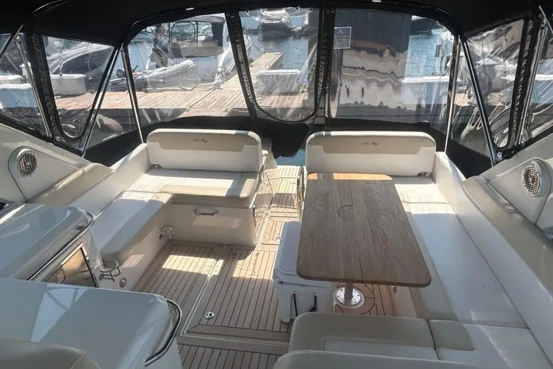  Yacht Photos Pics 2013 Searay 370 Venture boat interior with seating and wooden table, docked at marina.
