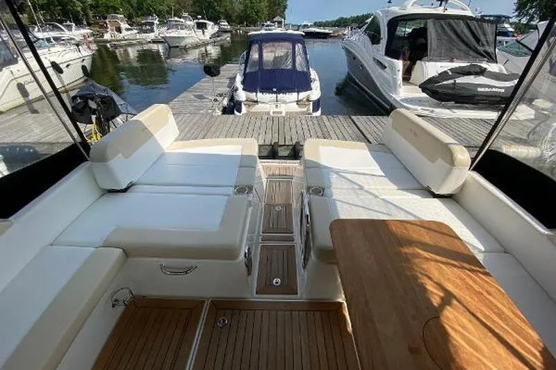  Yacht Photos Pics 2013 Searay 370 Venture yacht interior with white seating and wooden table at marina.