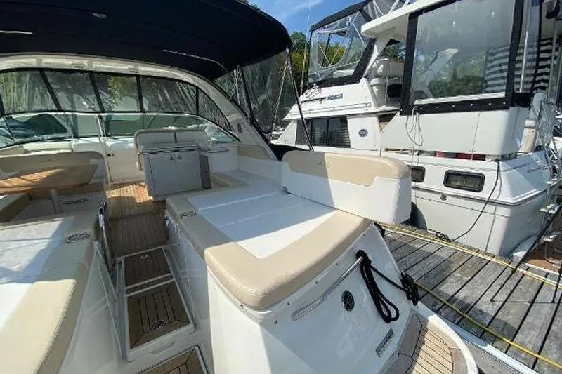  Yacht Photos Pics 2013 Searay 370 Venture boat interior with seating and canopy, docked beside another vessel.