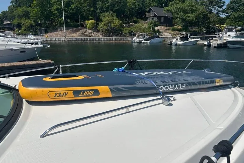  Yacht Photos Pics 2013 Searay 370 Venture with paddleboard on deck, docked near other boats.