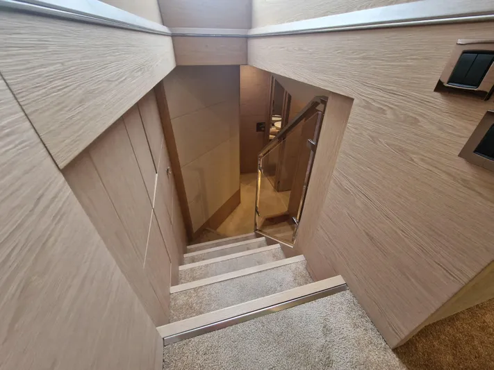 Sandrali Yacht Photos Pics Staircase inside 2016 Beneteau Monte Carlo 6 yacht, featuring modern wood paneling.