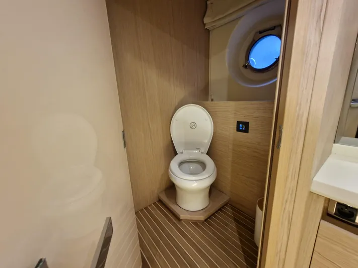 Sandrali Yacht Photos Pics Toilet area in 2016 Beneteau Monte Carlo 6 yacht with wooden interior and porthole window.