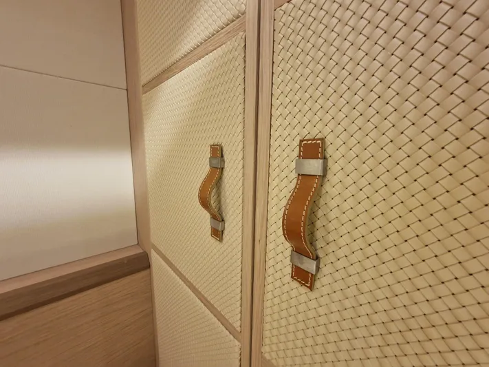 Sandrali Yacht Photos Pics Luxurious interior detail of 2016 Beneteau Monte Carlo 6 yacht with woven paneling and leather handles.